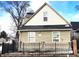 Tan house with black fence, visible snow, and a partially boarded window at 952 Udell St, Indianapolis, IN 46208