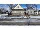 Two-house view, one tan and one gray, with black fences and snow on the ground at 952 Udell St, Indianapolis, IN 46208