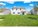 Large grassy backyard featuring a white two-story house, patio, and dining area at 977 Capricorn Dr, Franklin, IN 46131