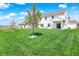 Spacious backyard with green lawn and a view of the two-story home with a covered patio at 977 Capricorn Dr, Franklin, IN 46131