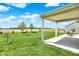 Backyard patio highlighting the covered structure with view of grassy backyard and farm field at 977 Capricorn Dr, Franklin, IN 46131