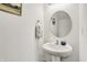 Simple bathroom with a pedestal sink, round mirror, and neutral decor at 977 Capricorn Dr, Franklin, IN 46131