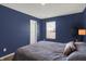 Cozy bedroom with dark blue walls, plush bedding, and natural light at 977 Capricorn Dr, Franklin, IN 46131