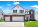 Inviting two-story home featuring a three-car garage and a well-manicured lawn at 977 Capricorn Dr, Franklin, IN 46131
