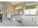 Light-filled bathroom featuring a soaking tub, granite countertops, and a large window with sheer draperies at 14832 Sulky Way, Carmel, IN 46032