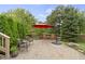 Outdoor brick patio with red umbrella and well-manicured landscaping at 14832 Sulky Way, Carmel, IN 46032