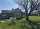 Weathered wood house with a large tree and small flowering bush at 1520 N Bancroft St, Indianapolis, IN 46201