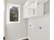 Bright laundry room with overhead shelving and built in cabinets at 201 S Mckinley St, North Salem, IN 46165