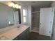 Bathroom with marble tiled shower, double sink vanity, and large mirror with vanity lighting at 2310 Marjorie Way, Shelbyville, IN 46176