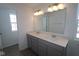 This bathroom offers a double vanity with hard-surface countertops, an elegant light fixture, and a large mirror at 2310 Marjorie Way, Shelbyville, IN 46176