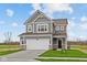 Charming two-story home with gray siding, white trim, two-car garage, and landscaped yard at 2310 Marjorie Way, Shelbyville, IN 46176