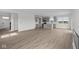 Open living space with luxury vinyl plank flooring, and an adjacent kitchen with stainless steel appliances at 2310 Marjorie Way, Shelbyville, IN 46176