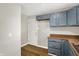 Kitchen with gray cabinets, brown countertops, and a white door at 2319 N Rural St, Indianapolis, IN 46218