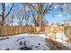 Fenced backyard with stone path and large tree, partially covered in snow at 2320 Spann Ave, Indianapolis, IN 46203