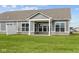 A gray house has an open backyard with a patio, complemented by a green lawn and light-colored stone accents at 3617 Wrangler Dr, Bargersville, IN 46106