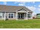 The backyard with green lawn has a house with a covered patio, white trim, and stone accents at 3617 Wrangler Dr, Bargersville, IN 46106