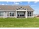Backyard featuring lush green lawn and a gray house with a covered porch, columns, and stone accents at 3617 Wrangler Dr, Bargersville, IN 46106