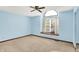 Bright bedroom features a ceiling fan, large window and neutral carpet at 4669 Stansbury Ln, Indianapolis, IN 46254