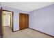 Bedroom features a neutral carpet, lilac walls, and a wood-paneled closet, offering a comfortable and organized space at 4669 Stansbury Ln, Indianapolis, IN 46254