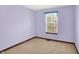 This cozy bedroom boasts soft lilac walls, neutral carpeting, and a sunny window for a relaxing retreat at 4669 Stansbury Ln, Indianapolis, IN 46254