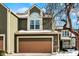 Two-story green house with a tan garage door and snowy yard at 4669 Stansbury Ln, Indianapolis, IN 46254