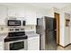 Modern kitchen with stainless steel appliances, white cabinetry, and a built-in microwave at 4669 Stansbury Ln, Indianapolis, IN 46254