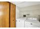 Functional laundry room with washer, dryer, and storage shelving, located conveniently near bedrooms at 4669 Stansbury Ln, Indianapolis, IN 46254