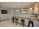 Basement bar area with light wood cabinets, sink, mirror, dart board and black bar stools at 6012 Yellow Birch Ct, Avon, IN 46123