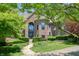Brick home with an arched entry, green landscaping, and a winding sidewalk to the front door at 6012 Yellow Birch Ct, Avon, IN 46123