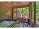 Enclosed sun room with a hot tub, screened windows, and a view of the outdoor deck and greenery at 6012 Yellow Birch Ct, Avon, IN 46123