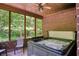 Relaxing sunroom with a hot tub surrounded by brick walls and a wooded view at 6012 Yellow Birch Ct, Avon, IN 46123