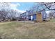 House back view, showcasing a deck, stone retaining wall, and fenced yard at 635 Terrace Dr, Zionsville, IN 46077