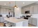 Modern kitchen with gray cabinets, white quartz island, and stainless steel appliances at 6957 Hornbeam Cir, Brownsburg, IN 46112