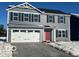 Two-story gray house with white garage doors and red front door at 7208 E Rising Sun N Cir, Camby, IN 46113