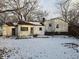 Rear view of the house showcasing a back patio and yard, covered in snow at 821 Shellbark Rd, Anderson, IN 46011