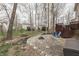 Backyard with fire pit area, picnic table, and chairs, surrounded by trees and offering outdoor recreation space at 10402 Shakamak Way, Indianapolis, IN 46239