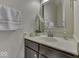 Clean bathroom with dark vanity, a large mirror, and fresh flowers at 10402 Shakamak Way, Indianapolis, IN 46239