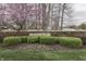 Stone wall and shrubbery at Wolf Run community entrance, accented by a beautiful flowering tree at 10402 Shakamak Way, Indianapolis, IN 46239