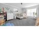 Bright Bedroom with neutral decor, a crib, a dresser, and a comfortable chair at 1102 N Newman St, Indianapolis, IN 46201