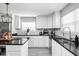 Bright kitchen with white cabinets, black countertops, and stainless steel appliances at 1102 N Newman St, Indianapolis, IN 46201