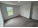 Bright, carpeted bedroom featuring a window with a lush outdoor view and a spacious closet at 116 Marble Wood Dr, Danville, IN 46122