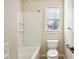 Bathroom featuring a tub and shower, toilet, towel bar, and a bright window at 14928 Declaration Dr, Westfield, IN 46074