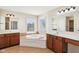 A luxurious bathroom featuring double vanities, a soaking tub, and abundant natural light from a large window at 14928 Declaration Dr, Westfield, IN 46074