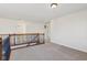 An upstairs hall landing featuring carpet, wooden railing and multiple bedroom doorways at 14928 Declaration Dr, Westfield, IN 46074