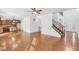 Open-concept living space with hardwood floors, staircase access, and a glimpse into the adjacent kitchen at 14928 Declaration Dr, Westfield, IN 46074
