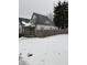 Snow covered lawn and charming craftsman style home with yellow door at 243 E Caven St, Indianapolis, IN 46225