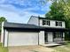 Updated two-story house with white brick, black roof, and a white garage door at 5619 Pappas Dr, Indianapolis, IN 46237