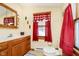 Clean bathroom with wood cabinets, a toilet, and red accents at 7018 Drum Dr, Nineveh, IN 46164