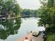 Picturesque lake view with dock, inviting swimming area and boat, surrounded by lush greenery at 7018 Drum Dr, Nineveh, IN 46164