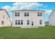 Two-story home featuring backyard with grassy lawn and patio at 7164 Firestone Rd, Whitestown, IN 46052